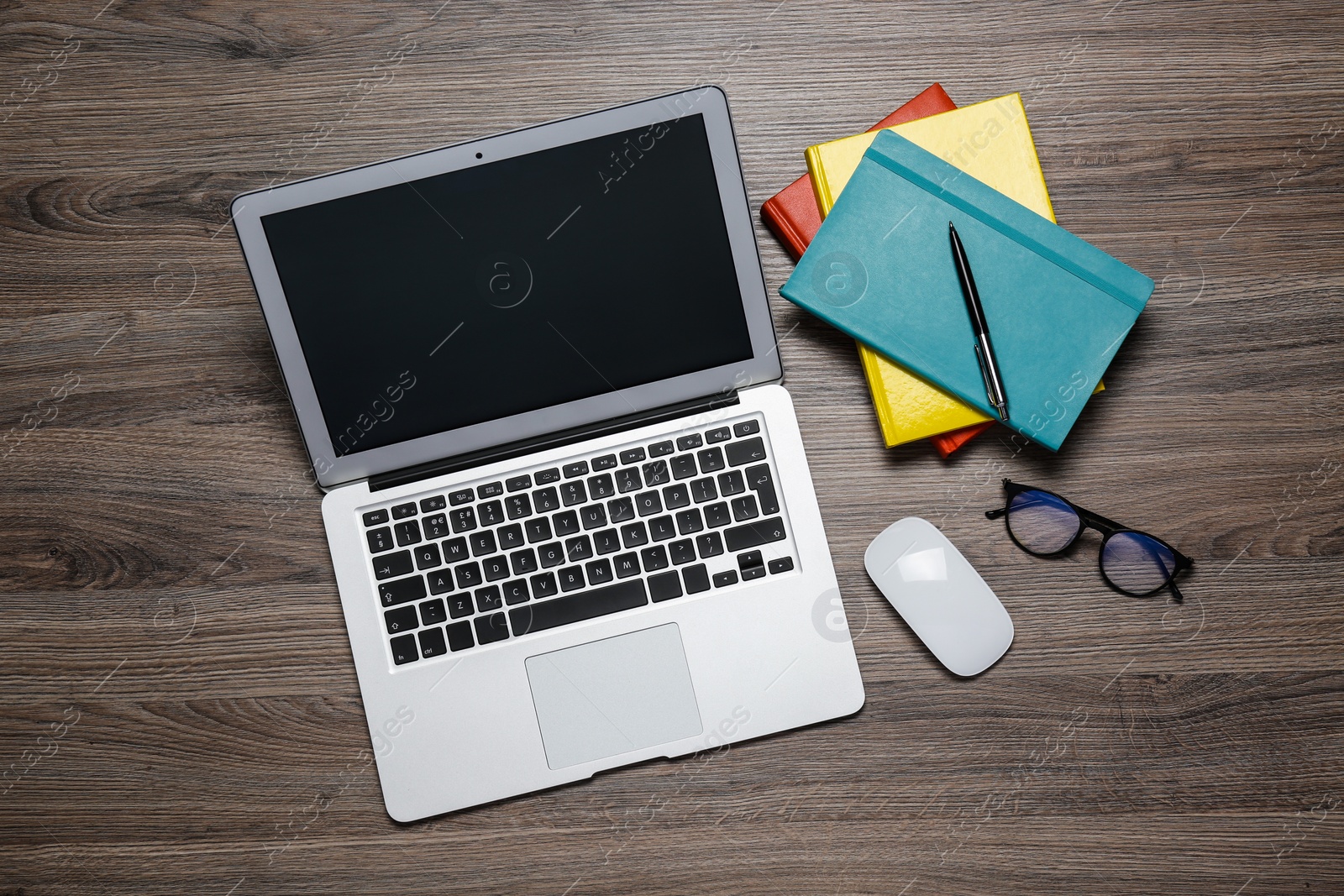 Photo of Modern laptop, glasses and office stationery on wooden table, flat lay. Distance learning