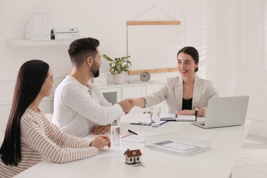 Photo of Real estate agent working with young couple in office. Mortgage concept