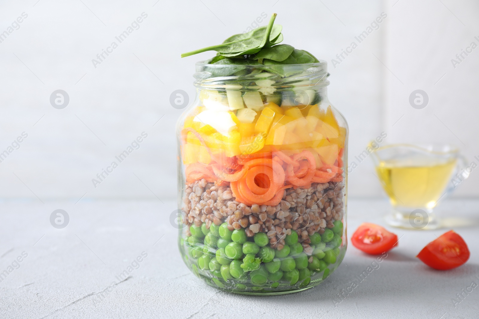 Photo of Healthy salad in glass jar on light table