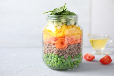 Healthy salad in glass jar on light table