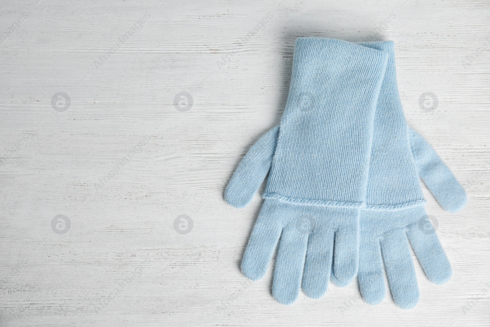 Photo of Stylish blue gloves on white wooden background, top view with space for text. Autumn clothes