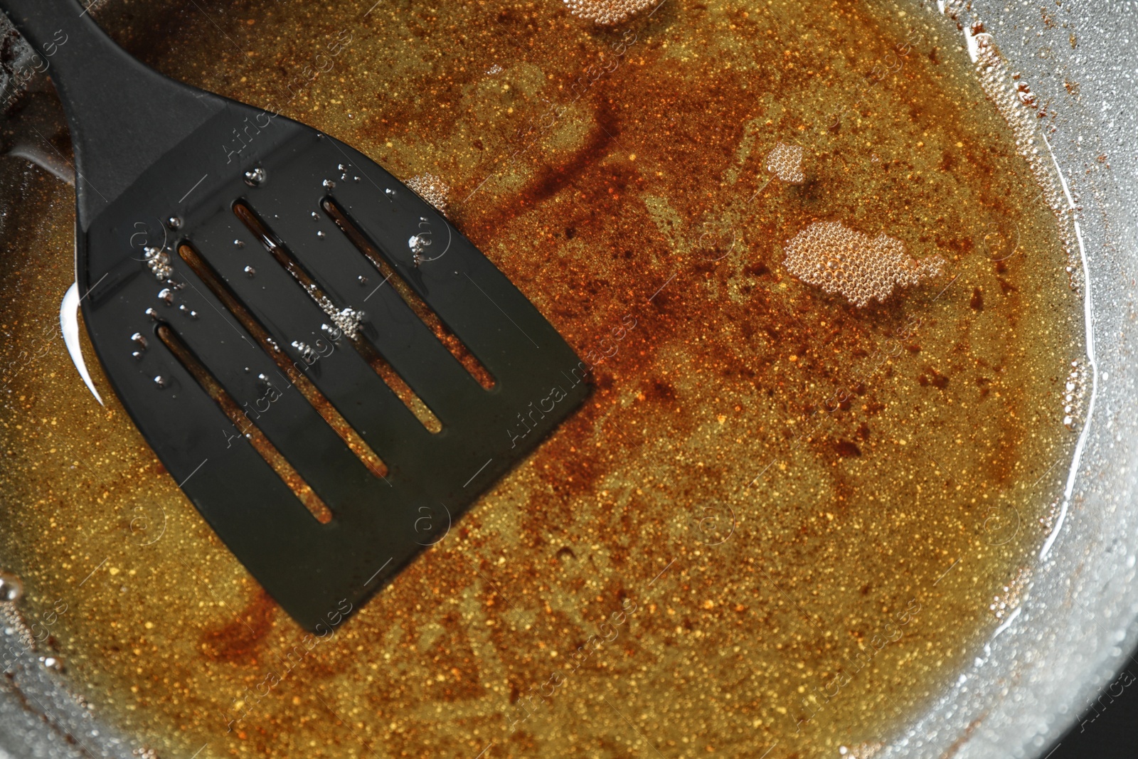 Photo of Used cooking oil in frying pan, closeup