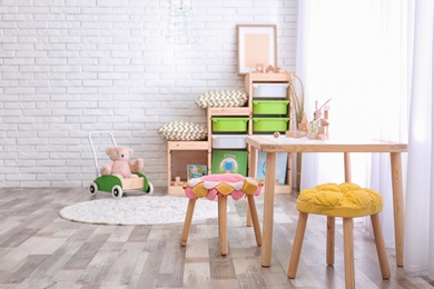 Photo of Modern eco style interior of child room with wooden crates near brick wall