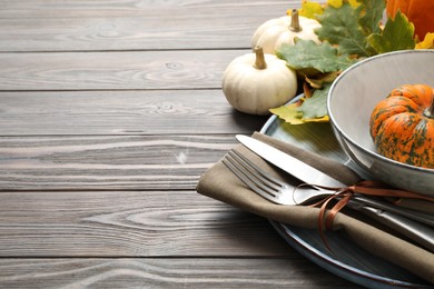 Photo of Festive table setting with pumpkins and space for text on wooden background, closeup. Thanksgiving Day celebration