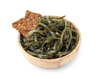 Tasty seaweed salad and crispbreads in bowl isolated on white