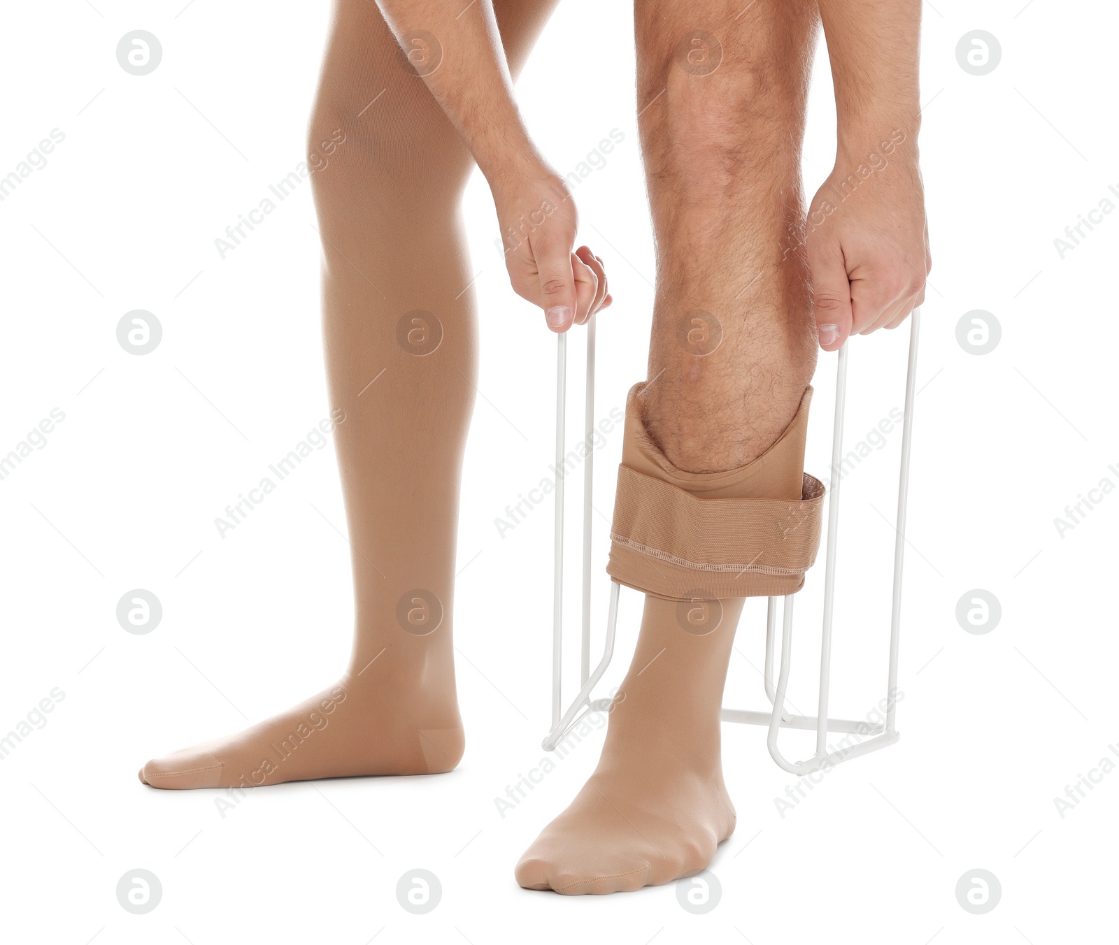 Photo of Man putting on compression garment with stocking donner against white background, closeup