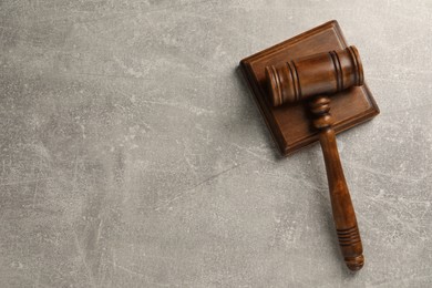 Photo of Wooden gavel on grey textured table, top view. Space for text