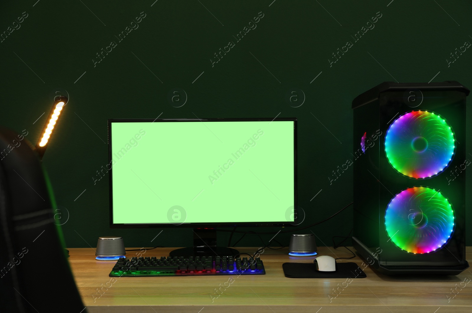 Photo of Modern computer and RGB keyboard on wooden table indoors. Mockup green screen