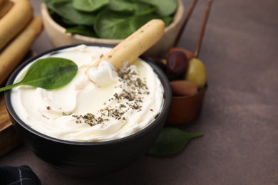 Photo of Delicious cream cheese with grissini stick and spices on grey table, closeup