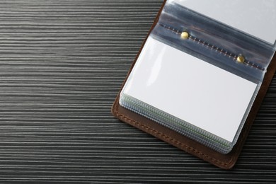 Leather business card holder with blank cards on grey table, top view. Space for text