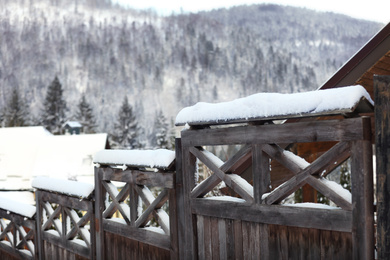 Photo of Wooden fence covered with snow outdoors on winter day