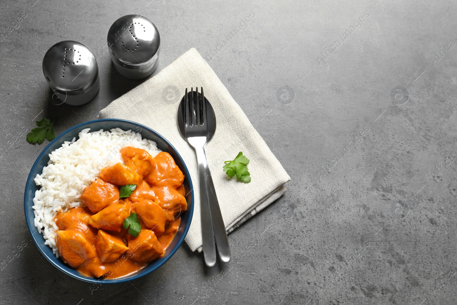 Photo of Butter chicken with rice served on grey table, flat lay. Space for text