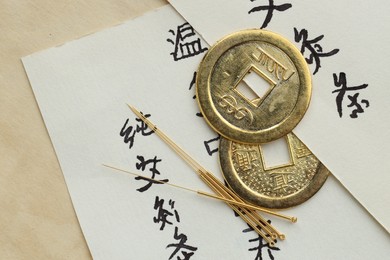 Photo of Flat lay composition with acupuncture needles and Chinese coins on paper