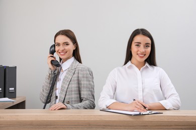 Female receptionists working at desk in hotel