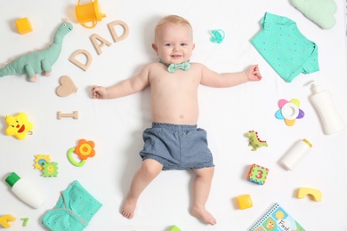 Photo of Cute little baby with clothing and accessories on white background, top view