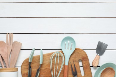 Photo of Set of different kitchen utensils on white wooden table, flat lay. Space for text