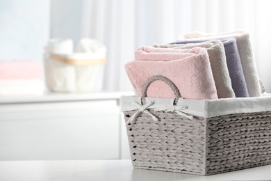 Photo of Basket of fresh towels on table. Space for text