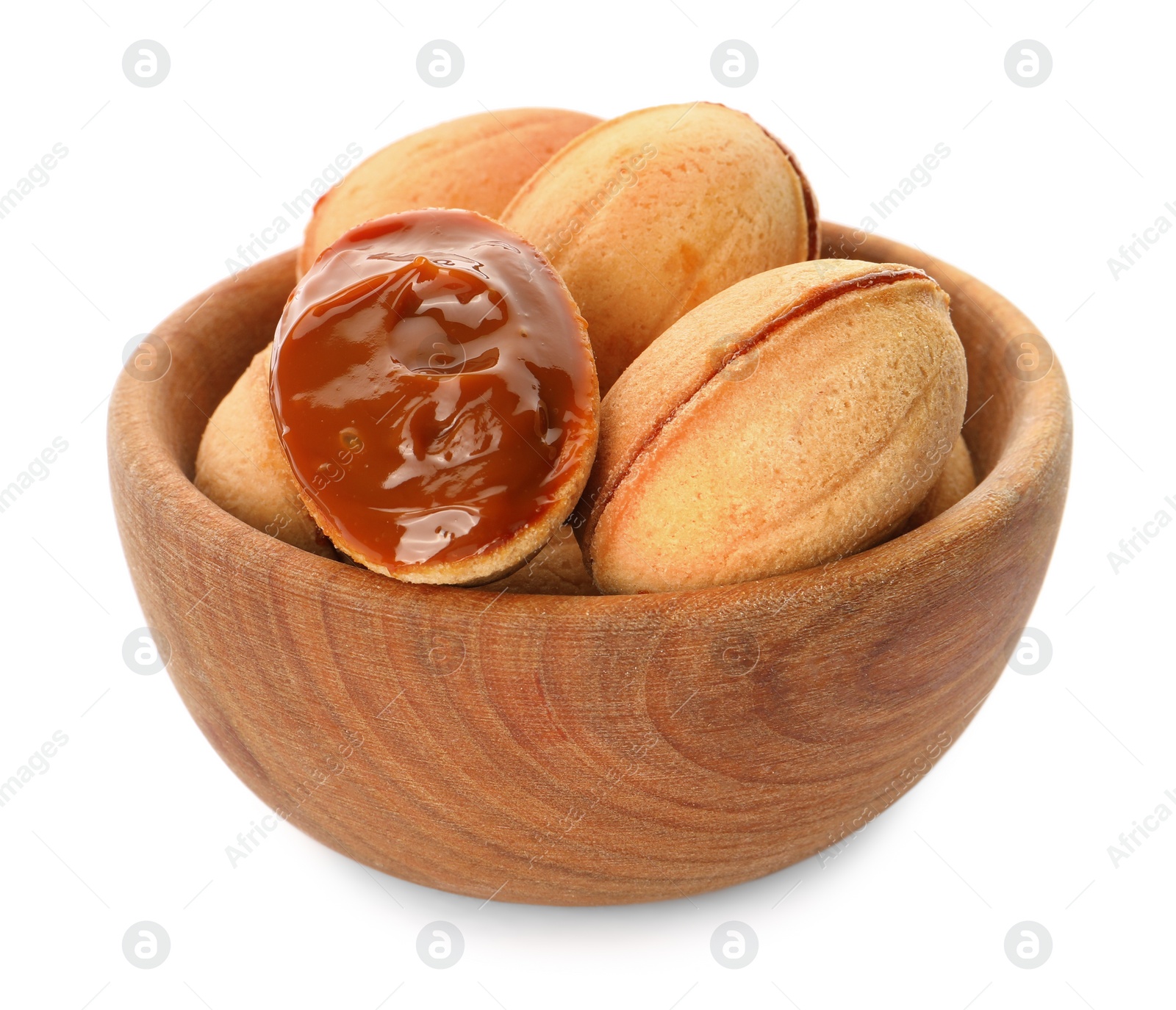 Photo of Delicious nut shaped cookies with boiled condensed milk in wooden bowl on white background