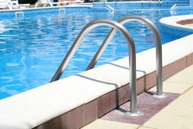 Photo of Swimming pool with metal ladder on sunny day