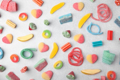 Photo of Many tasty colorful jelly candies on white table, flat lay