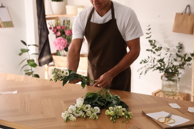 Florist making beautiful bouquet in workshop, closeup