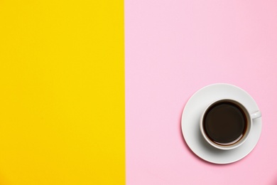 Photo of Cup of coffee on color background, top view. Space for text