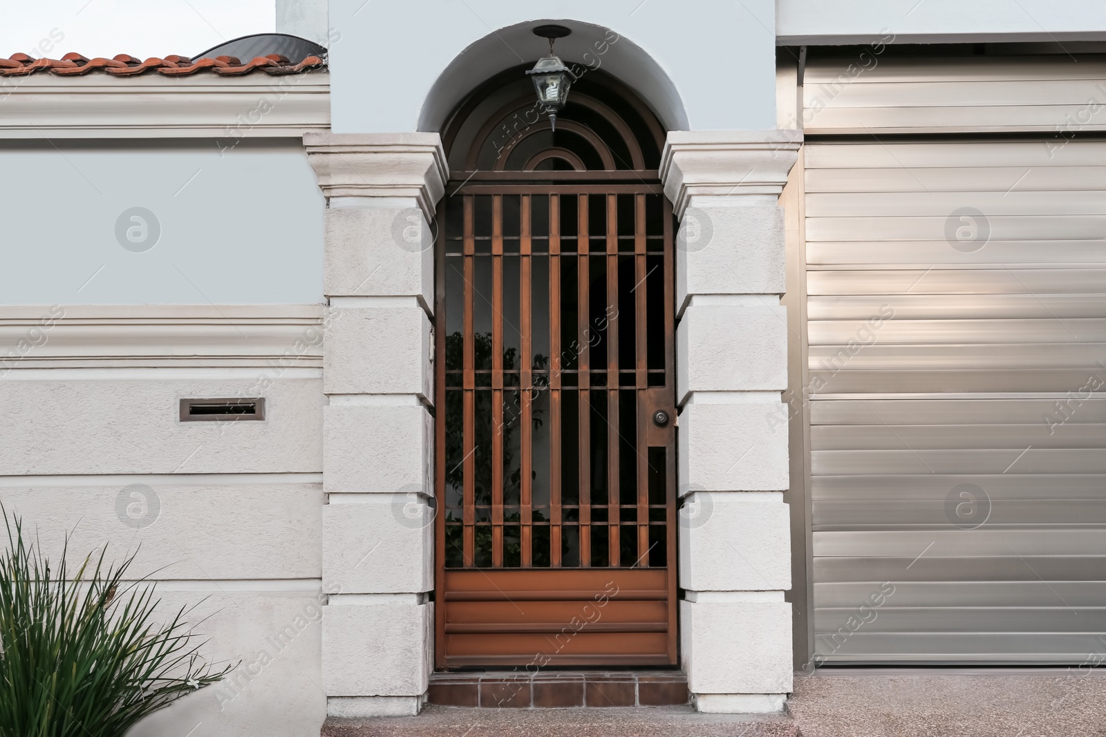 Photo of Closed metal door and fence outdoors on summer day