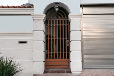 Photo of Closed metal door and fence outdoors on summer day