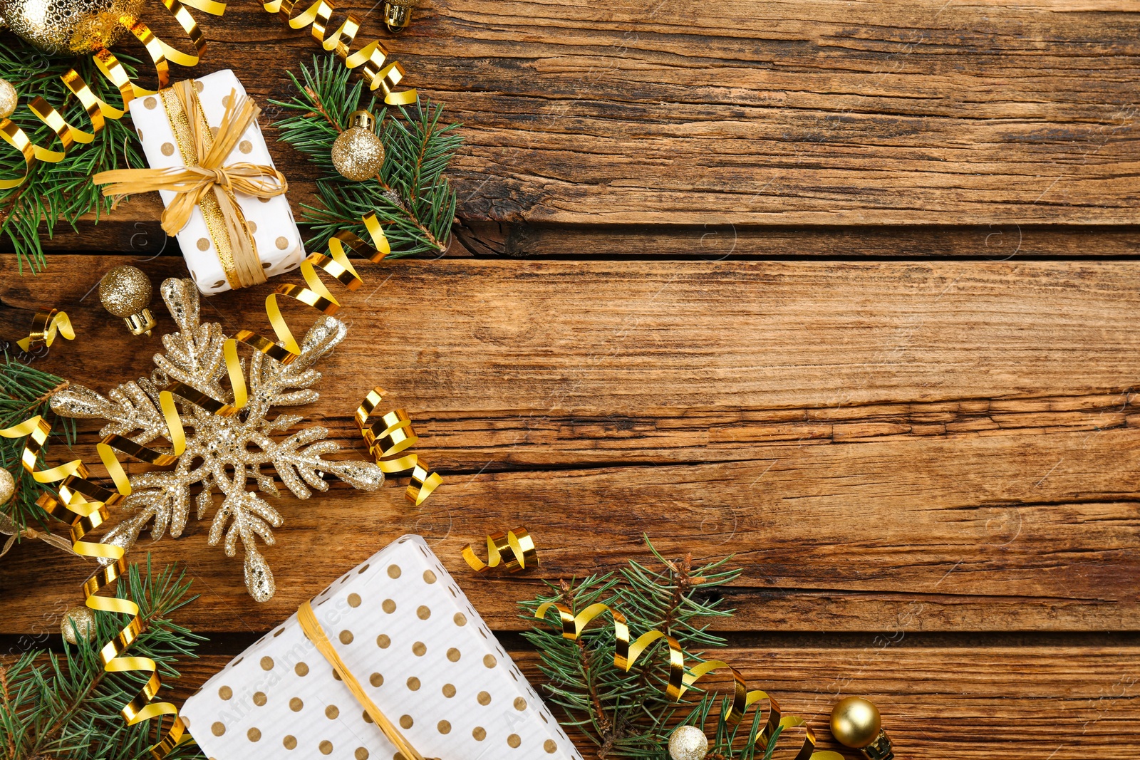 Photo of Flat lay composition with serpentine streamers and Christmas decor on wooden background. Space for text