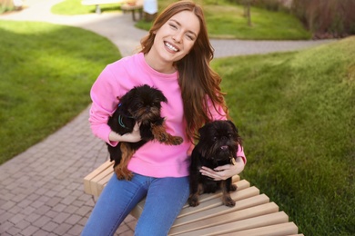 Photo of Young woman with adorable Brussels Griffon dogs outdoors