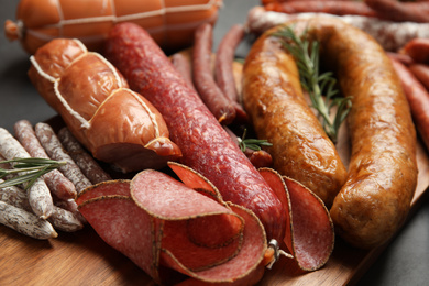Photo of Different tasty sausages on black table, closeup
