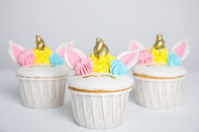 Photo of Cute sweet unicorn cupcakes on white table