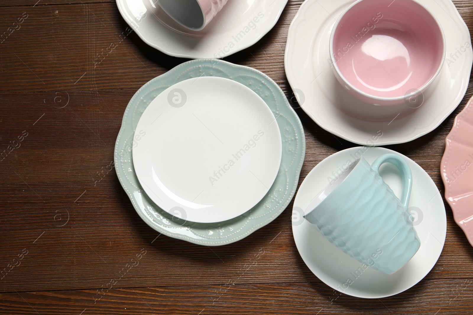 Photo of Beautiful ceramic dishware and cup on wooden table, flat lay