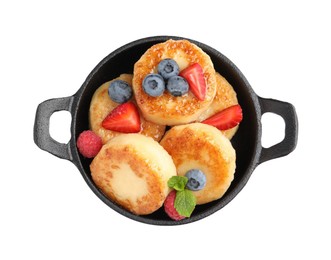 Delicious cottage cheese pancakes with fresh berries and honey on white background, top view