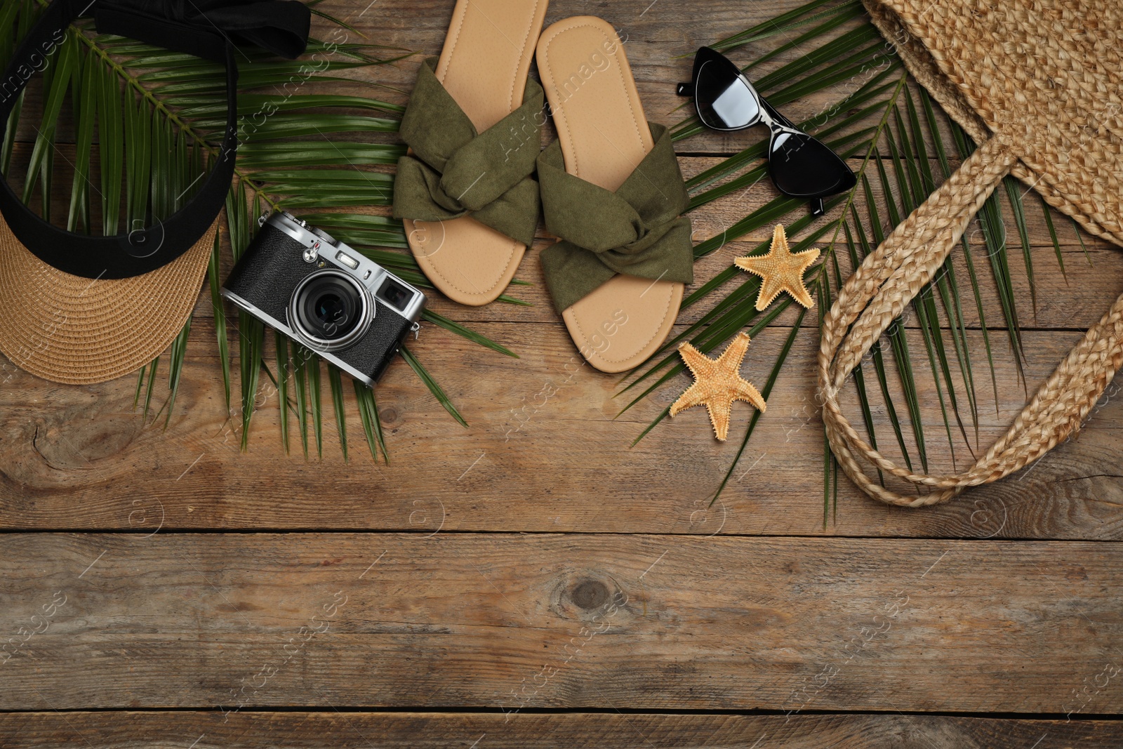 Photo of Flat lay composition with beach objects on wooden background, space for text