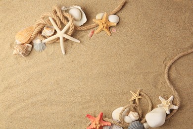 Photo of Beautiful sea stars, shells and ropes on sand, flat lay. Space for text
