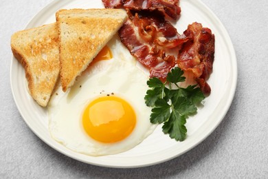 Photo of Delicious breakfast with sunny side up egg on light table, closeup