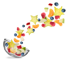 Image of Fresh tasty fruits and berries falling into bowl on white background