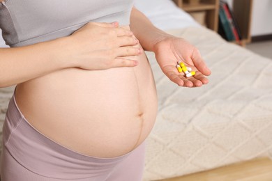 Photo of Pregnant woman taking pills at home, closeup. Space for text