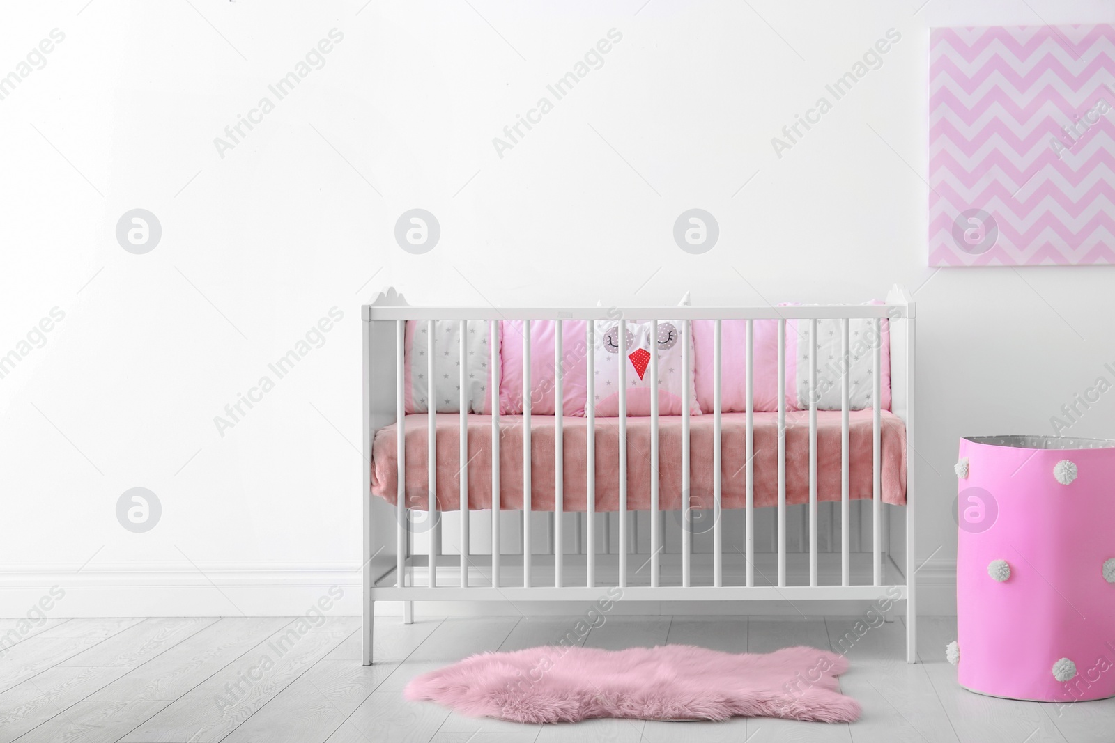 Photo of Baby room interior with crib near wall