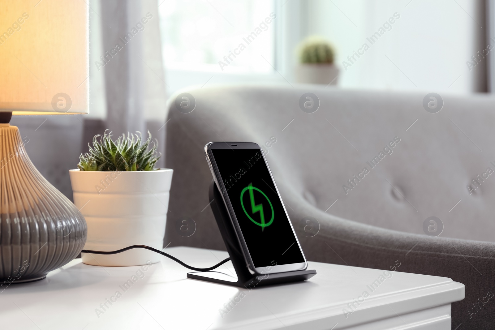 Photo of Smartphone charging on wireless pad in room