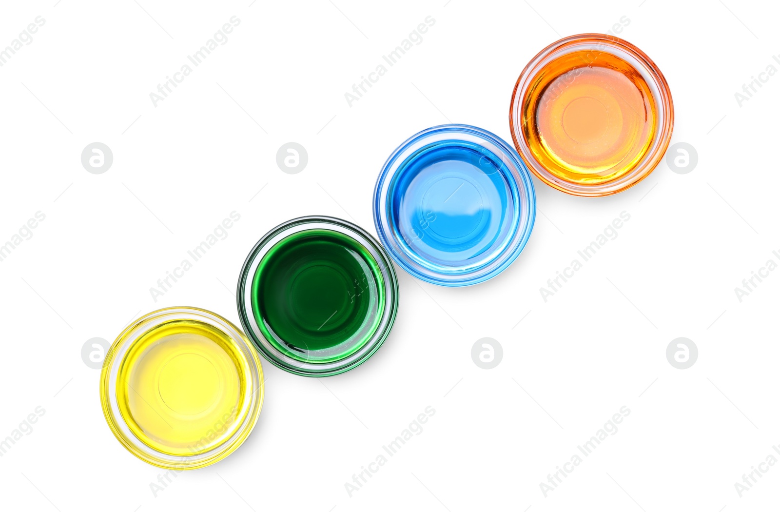 Photo of Glass bowls with different food coloring on white background, top view