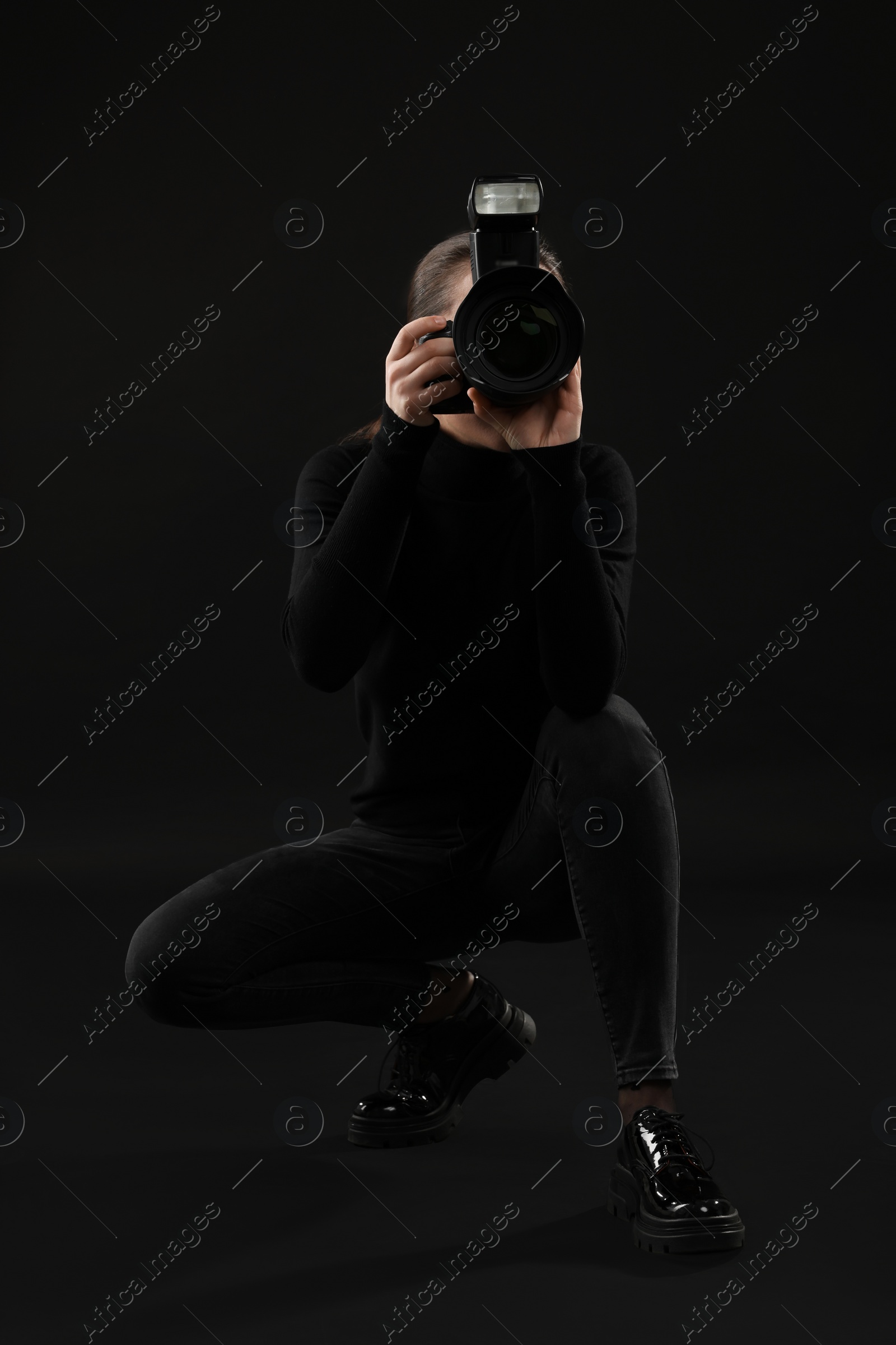 Photo of Professional photographer taking picture on black background