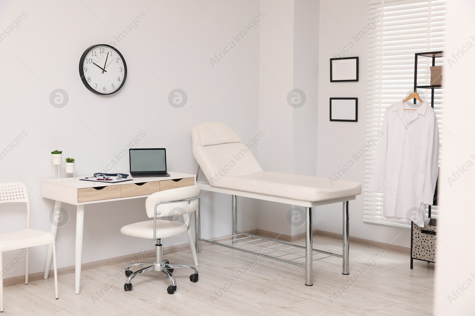 Photo of Modern medical office with doctor's workplace and examination table in clinic
