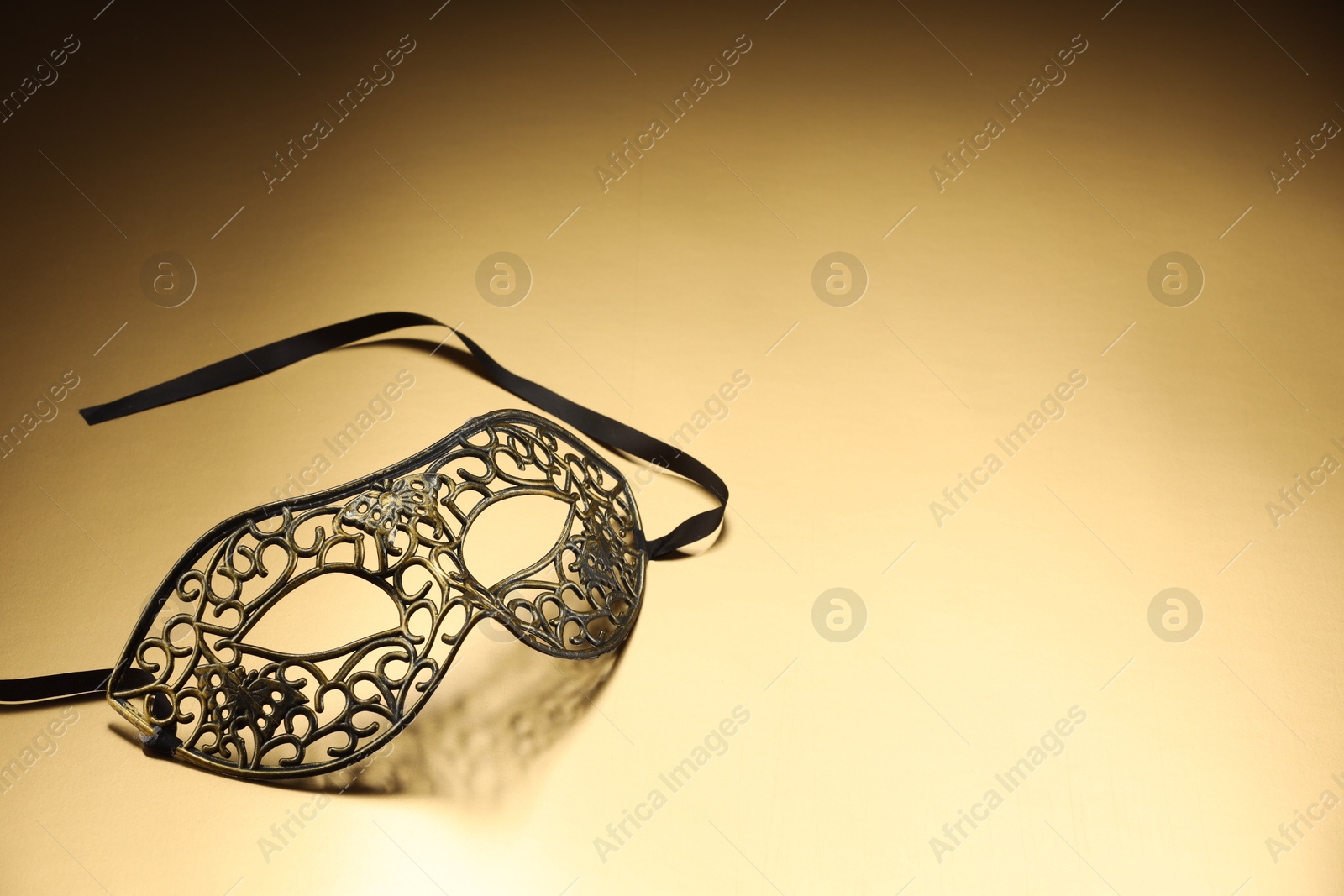 Photo of Elegant face mask on beige background, space for text. Theatrical performance