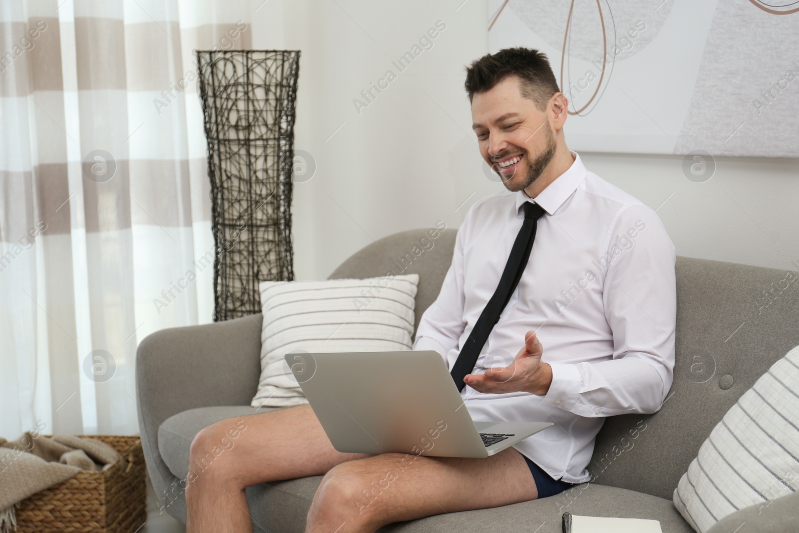 Photo of Businessman wearing shirt and underwear during video call at home