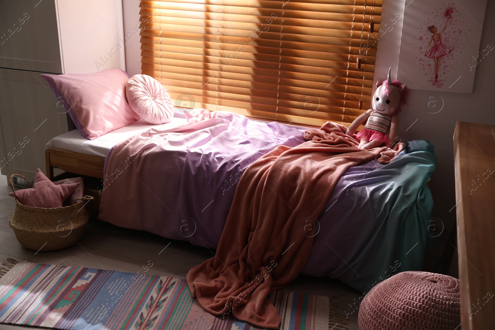 Photo of Bed with beautiful linens in children's room. Modern interior design