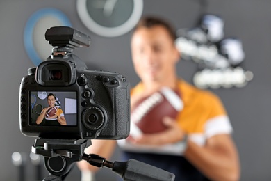Photo of Sport blogger recording video indoors, selective focus on camera display. Space for text