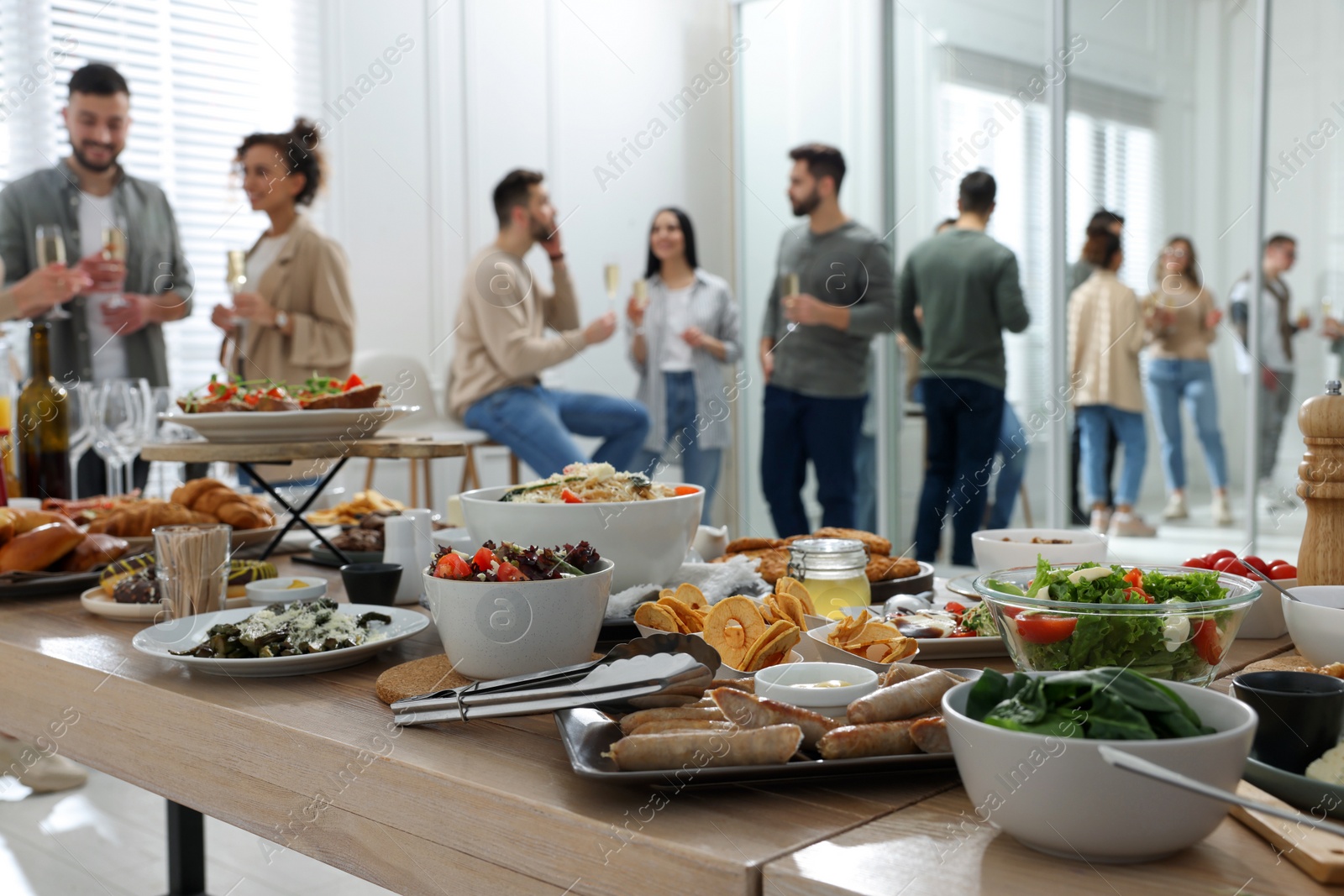 Photo of Brunch table setting with different delicious food	and blurred view of people on background