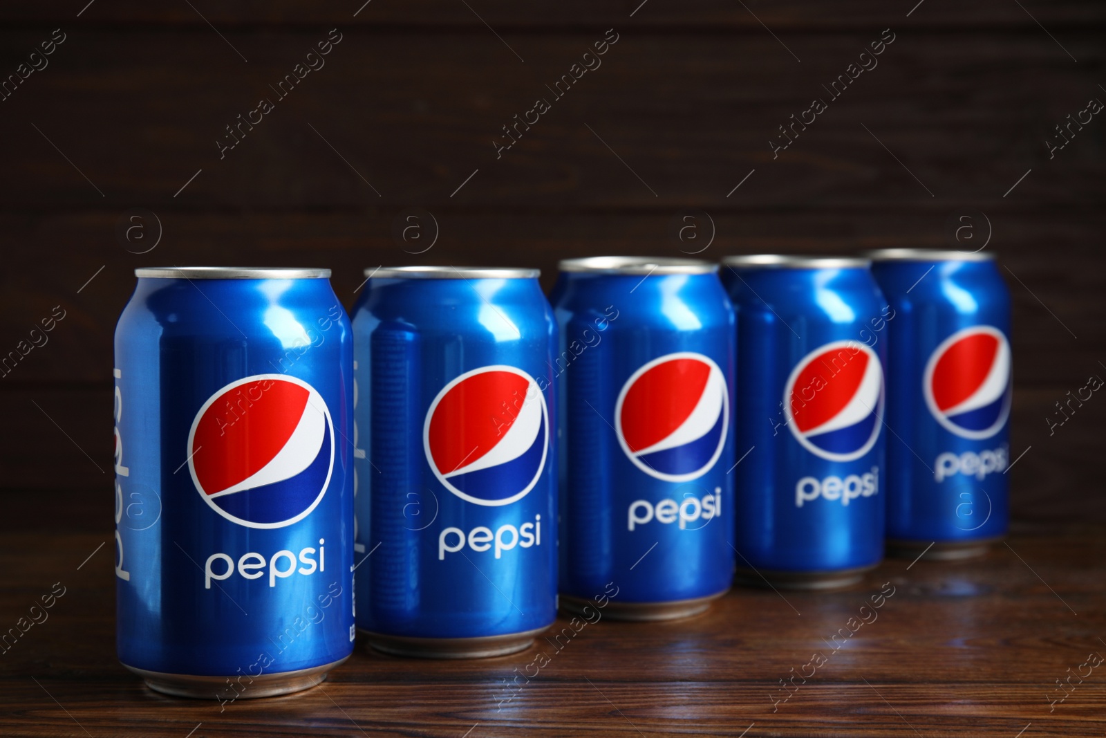 Photo of MYKOLAIV, UKRAINE - FEBRUARY 10, 2021: Cans of Pepsi on wooden table